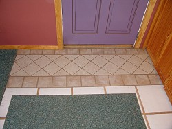 This ceramic tile rug right in front of the door is in lieu of ripping out all of the tile. Photo and tile repair by Kevin Stevens.