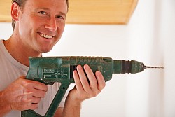 Photo of a man drilling with a power drill by nullplus/istockphoto.com.