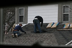 Photo of roofers installing asphalt shingles by waitscm/Flickr Creative Commons.
