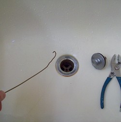 Here I am, goin' fishin' with a coat hanger. It's one DIY way to unclog a bathtub drain. --Phil