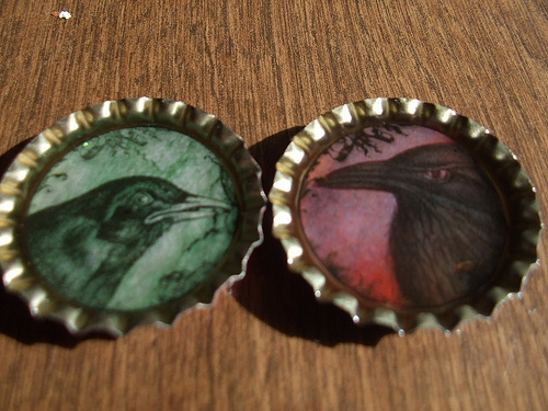 Photo of bottle cap magnets with painted ravens by JenHuff1/Flickr. Photo of bottle cap magnets with painted ravens by JenHuff1/Flickr.
