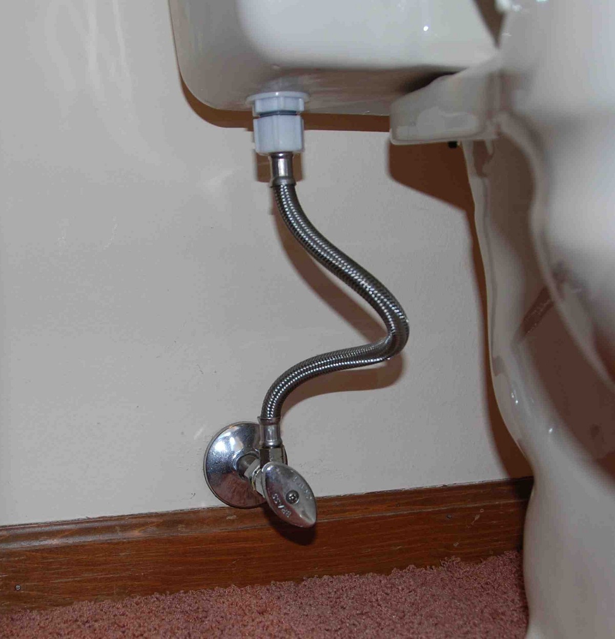 Shutoff valve (on wall, with football-shaped handle) and retaining nut