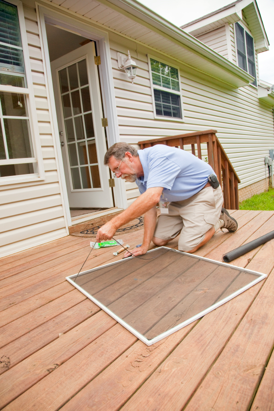 A contractor fixes a screen. Photo by Trigem777/istockphoto.com.