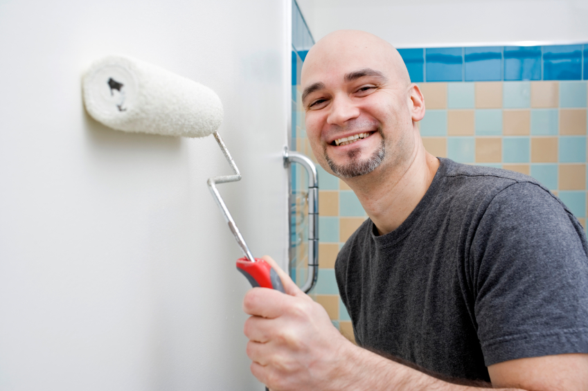 Photo of a DIY-er painting a bathroom wall by michellegibson/istockphoto.com. Photo of a DIY-er painting a bathroom wall by michellegibson/istockphoto.com.